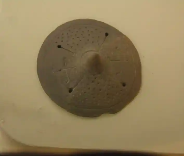 Two swastikas on a circular clay figure